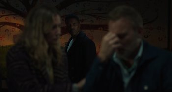 Movie still from “The Exorcist: Believer” (2023), directed by David Gordon Green – A group of people standing in a dark room; Medium shot, Over the shoulder angle