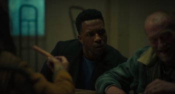 Movie still from “The Exorcist: Believer” (2023), directed by David Gordon Green – A man sitting at a table with other people around him; Medium shot, Over the shoulder angle