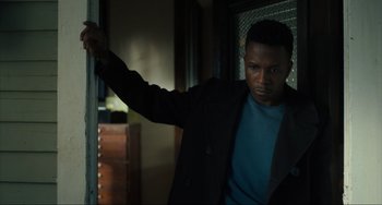 Movie still from “The Exorcist: Believer” (2023), directed by David Gordon Green – A man leaning against a wall in a room; Close Up shot, Low angle