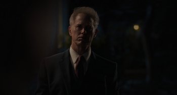 Movie still from “The Exorcist: Believer” (2023), directed by David Gordon Green – A man wearing a suit and tie standing in the dark; Close Up shot, Low angle