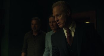 Movie still from “The Exorcist: Believer” (2023), directed by David Gordon Green – A man and two women in a dark room; Medium shot, Over the shoulder angle