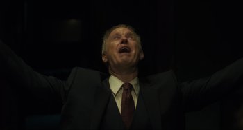 Movie still from “The Exorcist: Believer” (2023), directed by David Gordon Green – A man in a suit and tie with his mouth wide open; Close Up shot, Low angle