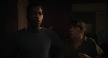 Movie still from “The Exorcist: Believer” (2023), directed by David Gordon Green – A man standing next to a woman in a dark room; Close Up shot, Over the shoulder angle