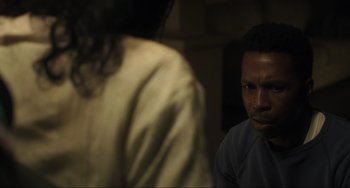 Movie still from “The Exorcist: Believer” (2023), directed by David Gordon Green – A man and a woman are sitting in a dimly - lit room; Close Up shot, Over the shoulder angle