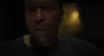 Movie still from “The Exorcist: Believer” (2023), directed by David Gordon Green – A man's face in a dark room; Close Up shot, Low angle