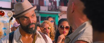 Movie still from “The Fate of the Furious” (2017), directed by F. Gary Gray – A group of people standing next to each other on the street; Close Up shot, Over the shoulder angle