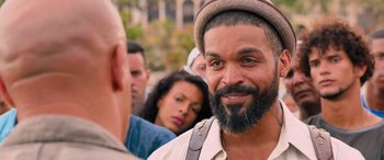 Movie still from “The Fate of the Furious” (2017), directed by F. Gary Gray – A man with a beard and a hat is looking at the camera; Close Up shot, Over the shoulder angle