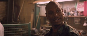 Movie still from “The Fate of the Furious” (2017), directed by F. Gary Gray – A man with a bald head in a room; Close Up shot, Over the shoulder angle