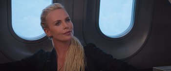 Movie still from “The Fate of the Furious” (2017), directed by F. Gary Gray – A woman sitting on top of an airplane looking out the window; Close Up shot, Over the shoulder angle