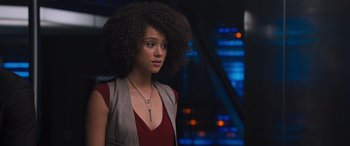 Movie still from “The Fate of the Furious” (2017), directed by F. Gary Gray – A woman with a large afro is standing in front of a building; Close Up shot, Over the shoulder angle
