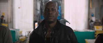 Movie still from “The Fate of the Furious” (2017), directed by F. Gary Gray – A man wearing a leather jacket and a plaid shirt; Close Up shot, Low angle
