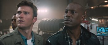 Movie still from “The Fate of the Furious” (2017), directed by F. Gary Gray – Two men standing next to each other in a warehouse; Close Up shot, Low angle