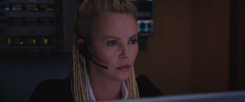 Movie still from “The Fate of the Furious” (2017), directed by F. Gary Gray – A woman with blonde dreadlocks wearing a headset; Close Up shot, Low angle