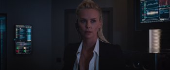 Movie still from “The Fate of the Furious” (2017), directed by F. Gary Gray – A woman with blonde hair is wearing a black suit; Close Up shot, Over the shoulder angle