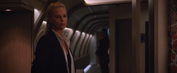 Movie still from “The Fate of the Furious” (2017), directed by F. Gary Gray – A woman standing in a tunnel with a man standing in the background; Medium shot, Over the shoulder angle