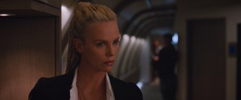 Movie still from “The Fate of the Furious” (2017), directed by F. Gary Gray – A woman with blonde hair wearing a white shirt and a black jacket; Close Up shot, Over the shoulder angle