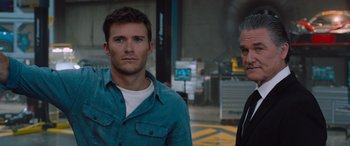 Movie still from “The Fate of the Furious” (2017), directed by F. Gary Gray – A man standing next to another man on a city street; Close Up shot, Low angle