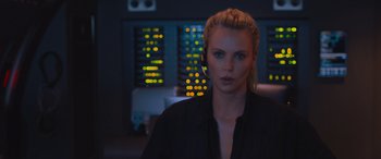 Movie still from “The Fate of the Furious” (2017), directed by F. Gary Gray – A woman in a black shirt is in front of some lights; Close Up shot, Over the shoulder angle