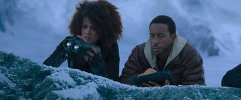 Movie still from “The Fate of the Furious” (2017), directed by F. Gary Gray – A man and a woman looking at something in the snow; Medium shot, Low angle