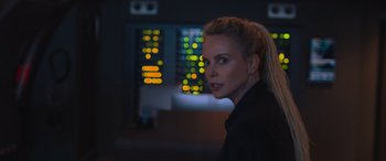 Movie still from “The Fate of the Furious” (2017), directed by F. Gary Gray – A woman in black shirt standing in front of a window; Close Up shot, Over the shoulder angle