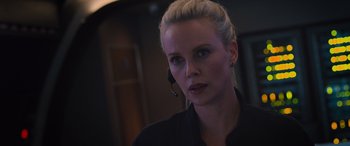 Movie still from “The Fate of the Furious” (2017), directed by F. Gary Gray – A woman wearing a headset looking into the distance; Close Up shot, Over the shoulder angle