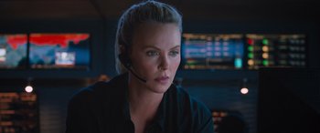 Movie still from “The Fate of the Furious” (2017), directed by F. Gary Gray – A woman wearing a headset in front of a computer screen; Close Up shot, Over the shoulder angle