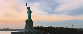 Movie still from “The Fate of the Furious” (2017), directed by F. Gary Gray – The statue of liberty is lit up at sunset; Extreme Wide shot, Low angle