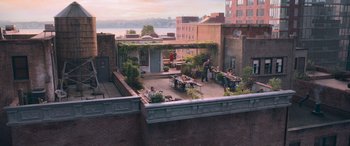 Movie still from “The Fate of the Furious” (2017), directed by F. Gary Gray – People are sitting at tables on a roof top patio; Extreme Wide shot, High angle