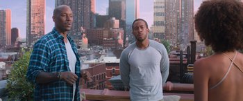 Movie still from “The Fate of the Furious” (2017), directed by F. Gary Gray – A man and a woman standing in front of a city skyline; Medium shot, Over the shoulder angle
