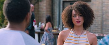 Movie still from “The Fate of the Furious” (2017), directed by F. Gary Gray – A woman with a very large afro is standing in front of other people; Close Up shot, Over the shoulder angle