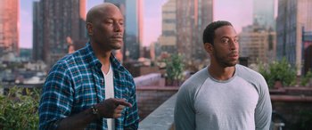 Movie still from “The Fate of the Furious” (2017), directed by F. Gary Gray – Two men standing next to each other on a balcony; Medium shot, Over the shoulder angle
