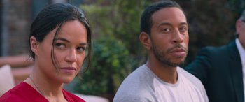 Movie still from “The Fate of the Furious” (2017), directed by F. Gary Gray – A man and a woman standing next to each other in front of trees; Close Up shot, Over the shoulder angle