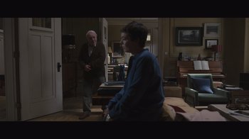 Movie still from “The Father” (2020), directed by Florian Zeller – A man and a woman playing a video game in a living room; Wide shot, High angle