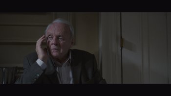 Movie still from “The Father” (2020), directed by Florian Zeller – An older man sitting in a room with his hand to his face; Close Up shot, Over the shoulder angle