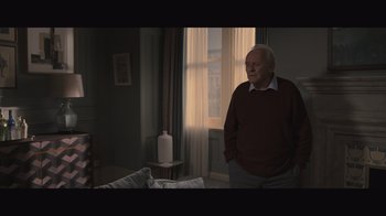 Movie still from “The Father” (2020), directed by Florian Zeller – An older man standing in a room next to a window; Medium shot, Over the shoulder angle