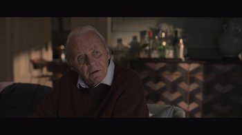 Movie still from “The Father” (2020), directed by Florian Zeller – An older man sitting in a chair in a room; Close Up shot, Over the shoulder angle