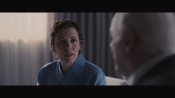 Movie still from “The Father” (2020), directed by Florian Zeller – A woman sitting in front of a man in front of a curtain; Close Up shot, Over the shoulder angle