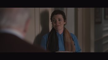 Movie still from “The Father” (2020), directed by Florian Zeller – A woman wearing a blue shirt with a brown scarf around her neck; Medium shot, Over the shoulder angle