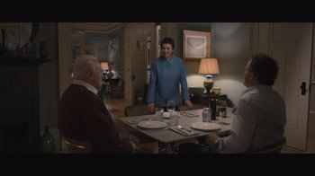 Movie still from “The Father” (2020), directed by Florian Zeller – A group of people sitting around a dining room table; Wide shot, High angle