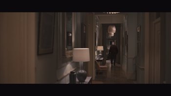 Movie still from “The Father” (2020), directed by Florian Zeller – A man walking down the hall way of a house; Wide shot, High angle