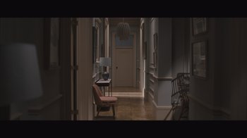 Movie still from “The Father” (2020), directed by Florian Zeller – A hallway with a chair , desk , lamp and a lamp; Wide shot, High angle