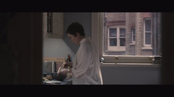 Movie still from “The Father” (2020), directed by Florian Zeller – A person standing in front of a window in a room; Medium shot, Low angle