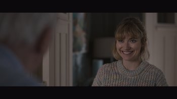 Movie still from “The Father” (2020), directed by Florian Zeller – A woman smiling for the camera while wearing a sweater; Close Up shot, Over the shoulder angle
