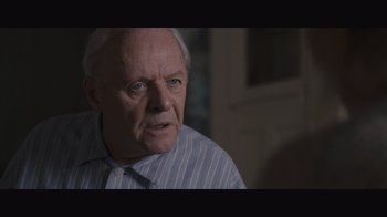 Movie still from “The Father” (2020), directed by Florian Zeller – An older man in a blue striped shirt looks at the camera; Close Up shot, Over the shoulder angle