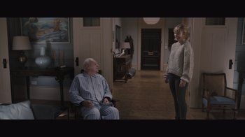 Movie still from “The Father” (2020), directed by Florian Zeller – A man and a woman are in a living room; Wide shot, High angle