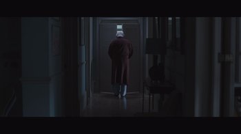 Movie still from “The Father” (2020), directed by Florian Zeller – An old man in a robe and a hat is walking down the hall way; Wide shot, Low angle