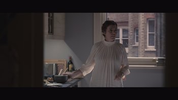 Movie still from “The Father” (2020), directed by Florian Zeller – A woman standing in front of a window in a kitchen; Medium shot, Low angle