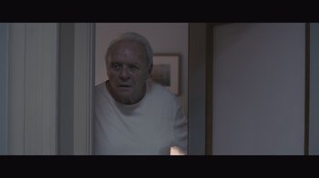 Movie still from “The Father” (2020), directed by Florian Zeller – A man in a white shirt is standing in front of a door; Medium shot, Low angle