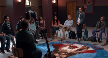 Movie still from “The Fault in Our Stars” (2014), directed by Josh Boone – A group of people sitting in a circle around a guitar; Wide shot, High angle