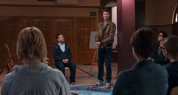 Movie still from “The Fault in Our Stars” (2014), directed by Josh Boone – A man standing in front of a group of people; Wide shot, Over the shoulder angle